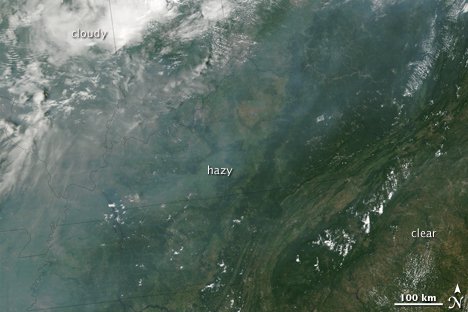 A band of haze hung over the southeastern United States on August 5 , 2002 . The haze is gray compared to the bright white clouds to the north. Haze blurs the ground beneath it. Ground features are distinct where skies were cleaner ( lower right ).